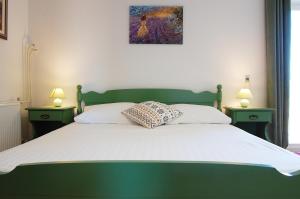 a bedroom with a green bed with two night stands at Apartment and rooms Jurišić in Korčula