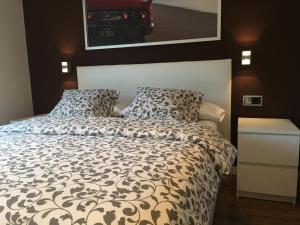 a bedroom with a bed with a black and white comforter at Beach House in Castelldefels +32 photos