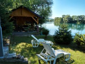 dos sillas y un cenador junto a un lago en Holiday home Una-Mia, en Bihać