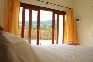 a bedroom with a bed and a large window at Naga Peak Resort in Ao Nang Beach