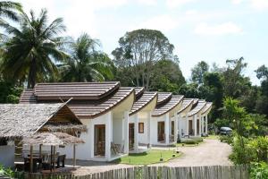 a row of white buildings with trees in the background at Naga Peak Resort in Ao Nang Beach +12 photos