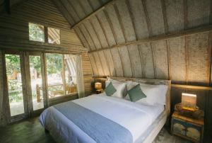 a bedroom with a bed in a wooden room at Flowers & Fire Yoga Garden in Gili Islands +63 photos