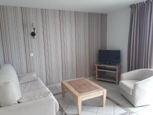 uma sala de estar com um sofá, uma televisão e uma mesa em appartement bord de mer em Fouesnant