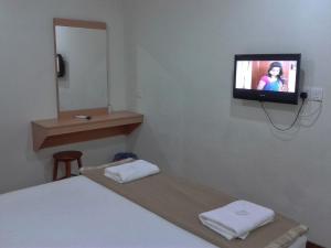 a room with a bed and a tv on the wall at Hotel Sri Malim Sungkai in Sungkai