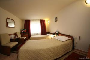 a hotel room with two beds and a chair at Euro Hotel in Timişoara
