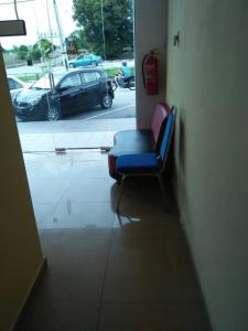 a blue chair in a room with a parking lot at Hotel Sri Malim Sungkai in Sungkai