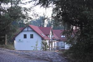 a house with a red roof and a white house at Siedlisko Kłodno in Sulęczyno