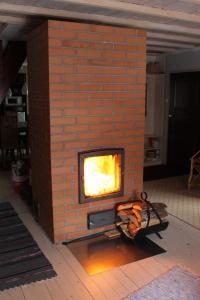 ラクヴェレにあるPosti Holiday Homeのレンガ造りの暖炉(レンガ造りの壁にテレビ付)