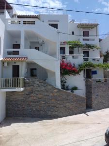 a white apartment building with stairs in front of it at Meltemi in Vourkari