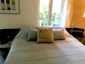 uma cama com uma almofada e uma janela em Bed&Brood Comon em Ubbergen