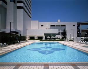 a large blue swimming pool in a building at Hotel Okura Kobe in Kobe