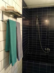 y baño con azulejos azules y toallas verdes. en Bed&Brood Comon en Ubbergen