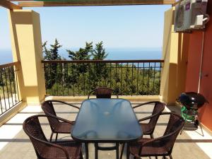 a table and chairs on a balcony with a view of the ocean at Scorpina Villas in Agios Nikitas