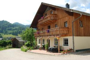 drewniany dom z balkonem na boku w obiekcie Reitbauernhof Schartner w mieście Altaussee
