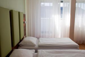 2 camas individuales en un dormitorio con ventana en Sky Apartments Vienna, en Viena