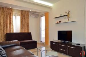 a living room with a couch and a flat screen tv at Utopia Apartments Ohrid in Ohrid