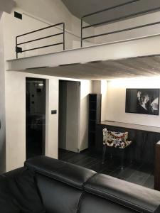 a living room with a couch and a loft bed at Loft Acaja in Fossano