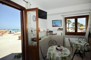 a room with a table and a view of the beach at Hotel Sòlanto in San Vito lo Capo