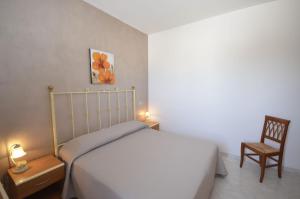 サン・ヴィート・ロ・カーポにあるHotel Sòlantoの小さなベッドルーム(ベッド1台、椅子付)