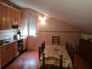 a kitchen with a table and a sink and a table and chairs at Casa y Apartamentos Nati in Carrascosa