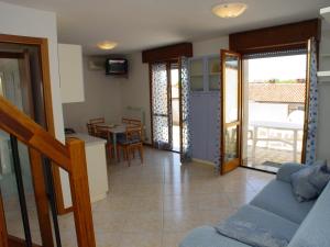 a living room with a couch and a table with chairs at San Pietro D'Orio Apartment in Grado