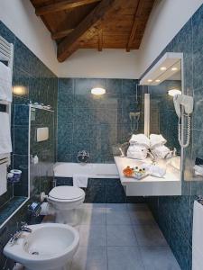y baño con lavabo, aseo y bañera. en Hotel Orologio, en Ferrara