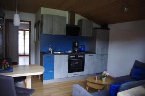 a kitchen with blue cabinets and a table in a room at Ferienwohnung Haus Alpenrebe in Schönau am Königssee
