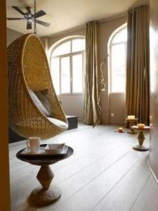 una camera con una sedia in vimini su un pavimento in legno di "Un Lieu Unique" Le Lodge et le Dolce ad Annecy
