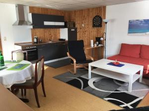 ein Wohnzimmer mit einem roten Sofa und einem Tisch in der Unterkunft Ferienwohnung Jucarm in Sankt Wendel