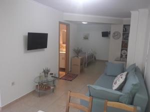 a living room with a blue couch and a table at Spiro's Apartment in Lefkada Town