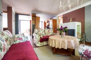 - un salon avec une table et un vase de fleurs dans l'établissement Papli Villa, à Pärnu