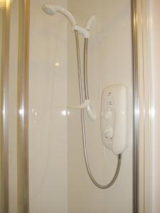 een douche met een telefoon in de badkamer bij Smithfield Guesthouse in Dounby