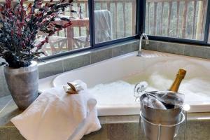 a bath tub with a bottle of champagne in it at Lemonthyme Wilderness Retreat in Moina