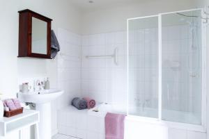 a white bathroom with a shower and a sink at Parker Lodge Maldon in Maldon