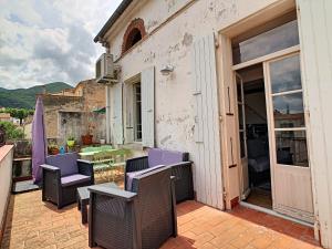 d'une terrasse avec des chaises et une table sur un balcon. dans l'établissement Le 52, à Céret