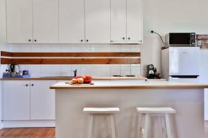 a kitchen with white cabinets and a counter with fruit on it at Parker Lodge Maldon in Maldon