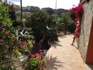un vialetto in un giardino con fiori e piante di Villa le Bougainvillea a La Maddalena