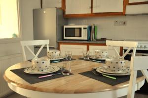 a wooden table with plates and glasses on top of it at Stunning Seaview Cottage in St Just