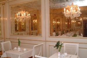 a dining room with two tables and a mirror at Hotel Belle Epoque in Venice