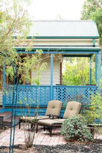 a patio with two chairs and a blue fence at Parker Lodge Maldon in Maldon