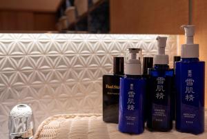 a group of three shampoo bottles sitting on a bed at Hotel Torifito Otaru Canal in Otaru +76 photos