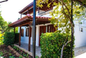 a white house with a wooden roof at Anemoesa in Batsi