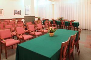 a conference room with a green table and chairs at Il Nocchiero City Hotel in Soverato Marina