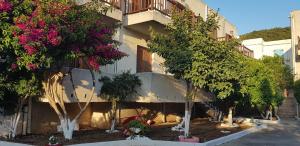 un edificio con un montón de árboles delante de él en Ilios Apartments, en Poros