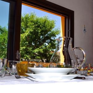 un tavolo con una brocca di vetro e dei bicchieri di Casa Duminicheddha, mare e relax in Gallura a Bassacutena