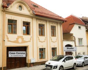 un edificio con dos coches estacionados frente a él en Casa Corona en Brasov