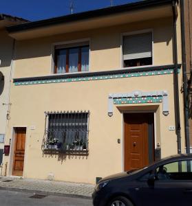 a house with a car parked in front of it at Casa Mario dei Pini in Viareggio
