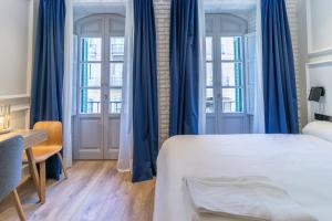 Łóżko lub łóżka w pokoju w obiekcie Livemalaga Centro Suites