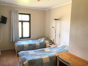 um quarto com duas camas e uma mesa e uma janela em Kerihovi em Kerimäki