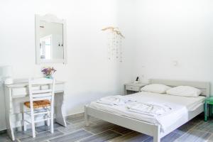 a white bedroom with a bed and a desk at Margo Antiparos in Antiparos +29 photos
